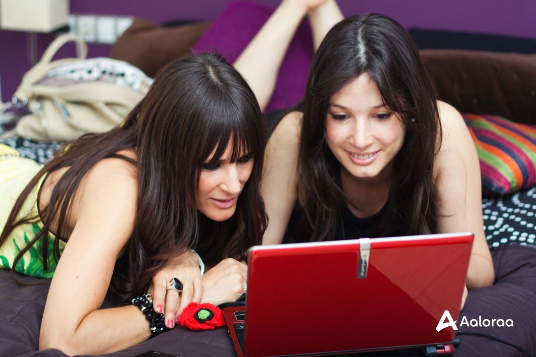 2 Girls Examining Computer 2 girls sharing and exchanging information as they examine things on their red computer.